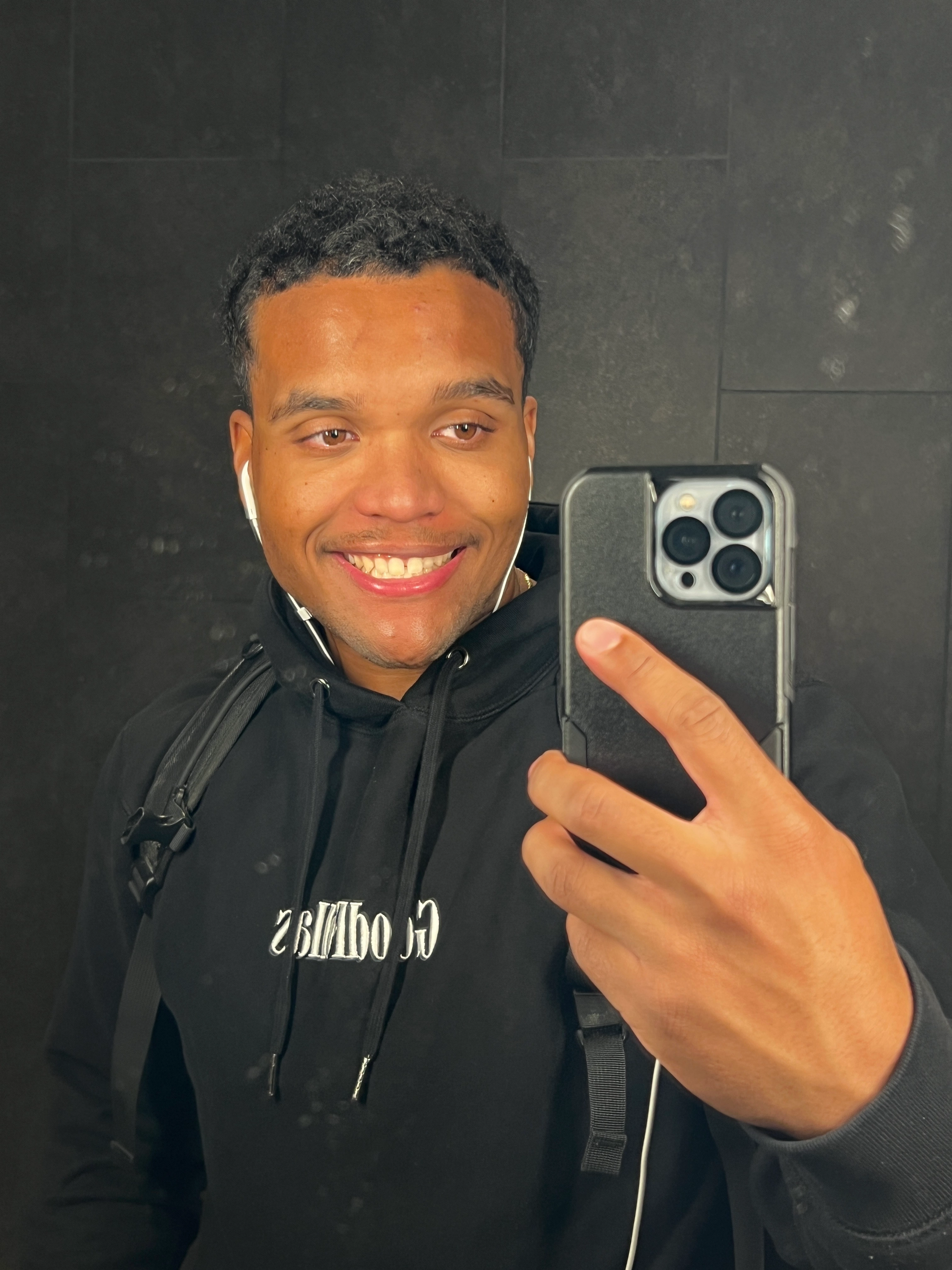 Dominick smiling, wearing a dark hoodie.